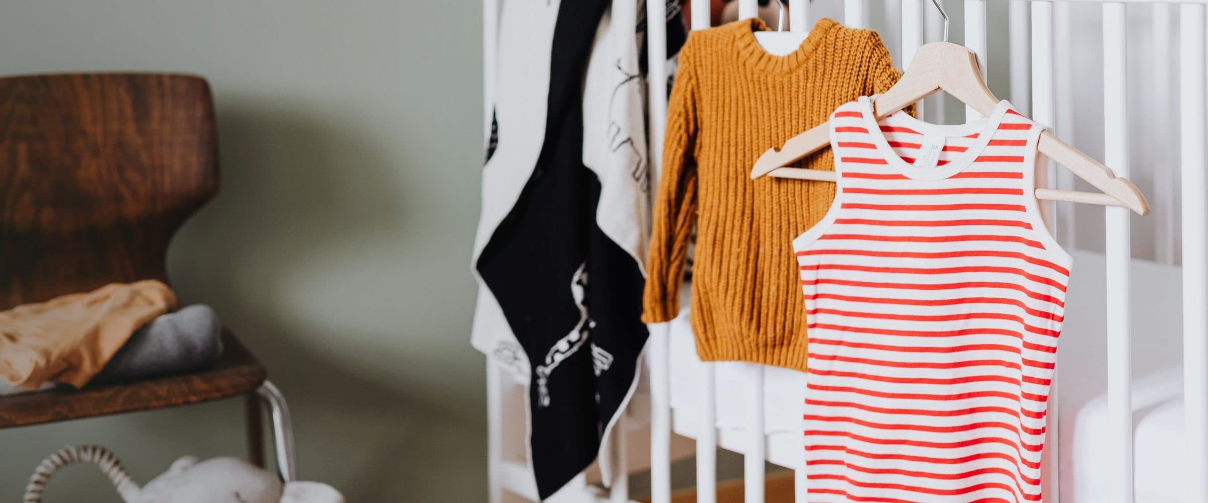 Vêtements d’enfant suspendus à un lit à barreaux